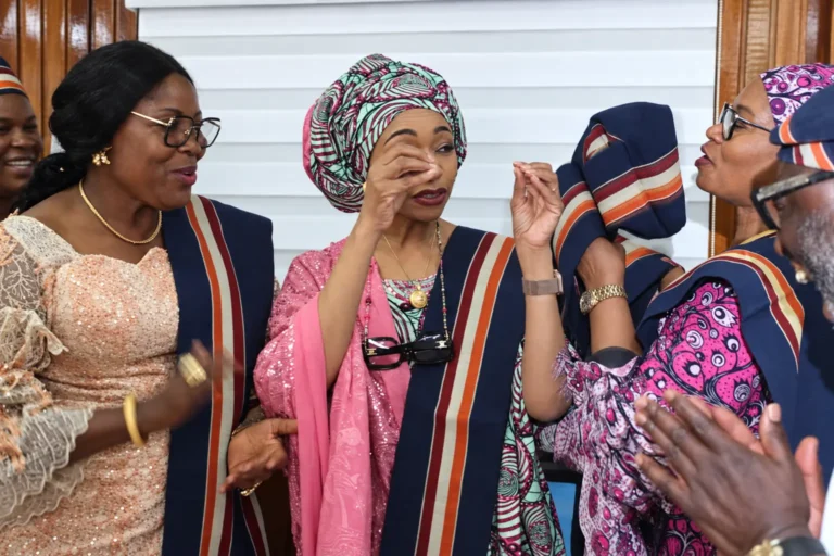 Community leaders in ceremonial sashes in conversation